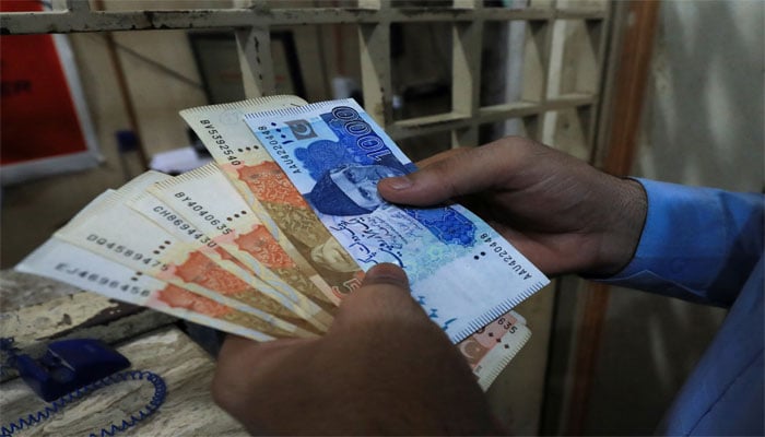 A man counts Pakistani rupee notes at a currency exchange shop in Peshawar, Pakistan September 12, 2023. — Reuters