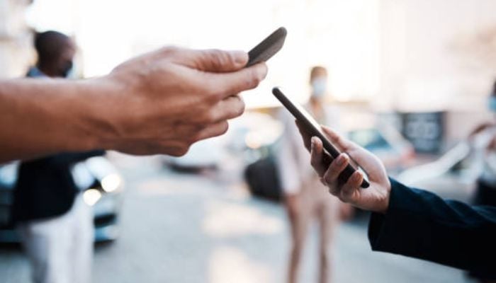 An undated image of two people using phones. — iStock