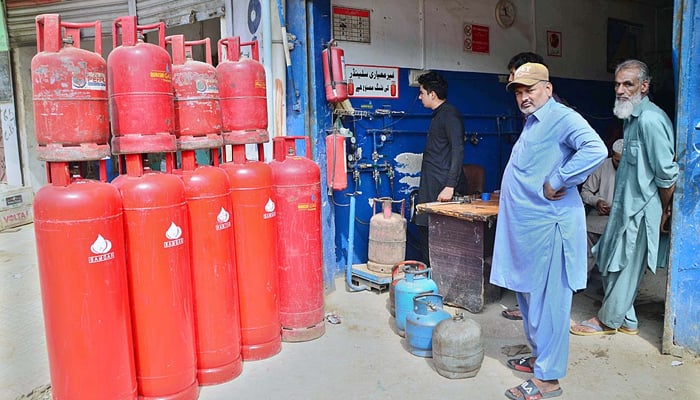People getting their LPG cylinders refilled from shop at Station Road in Hyderabad on October 24, 2021. — APP