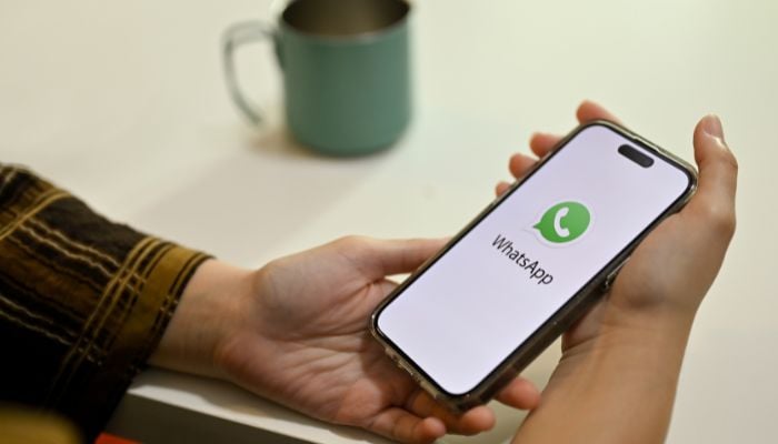An undated image of a person using WhatsApp. — Canva
