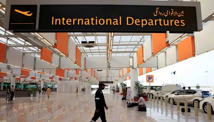 An image of airport staffer walks past the entrance of international departures at the Islamabad airport. — Reuters