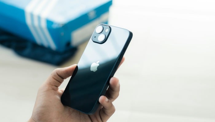 An undated image of a person holding iPhone. — Unsplash
