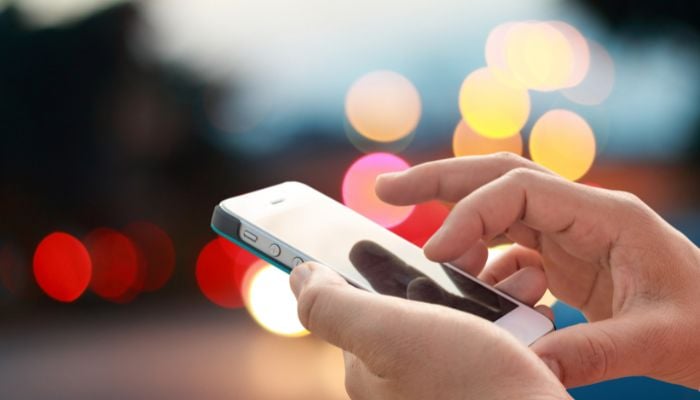 An undated image of a person using a phone. — Canva